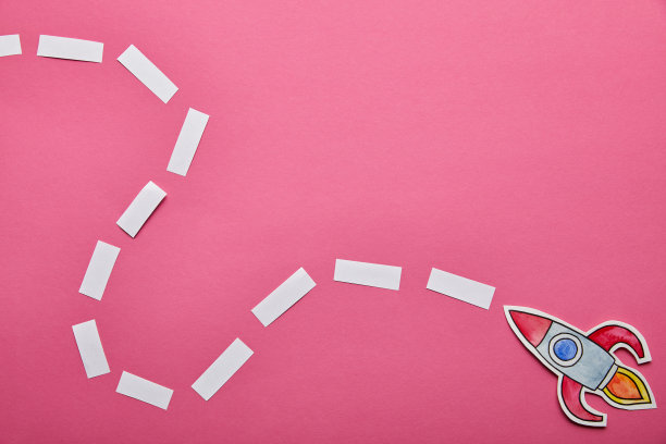 顶视图的火箭与方向上的粉红色背景图片下载