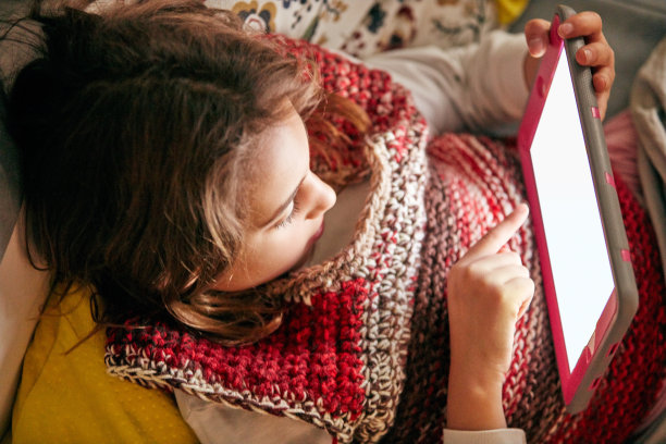 小女孩在家里用平板电脑学习和做作业。图片下载