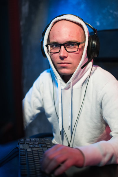 男兜帽玩家在电脑上玩在线游戏图片下载