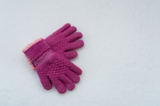 雪地背景上的粉色手套图片下载