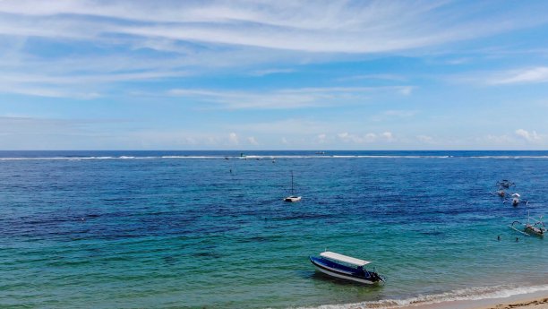 在蓝绿色的海水中，在田园诗般的海滩上的小船图片下载