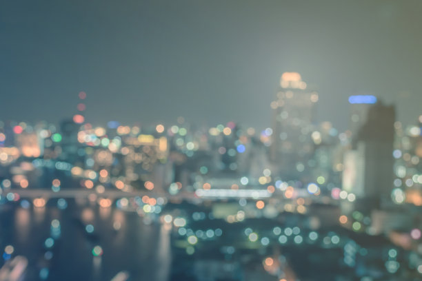 模糊的城市背景，城市景观屋顶视图，商业建筑景观，夜间灯光散景在复古的色调图片下载