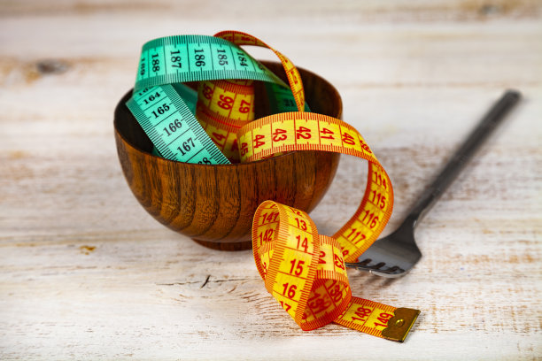 木碗和木叉里的卷尺。图片下载