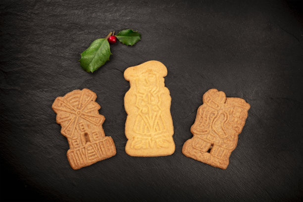 这张照片拍摄的是各种各样的传统圣诞节Spekulatius厨师，以冬青树的叶子为背景，从顶部拍摄图片下载