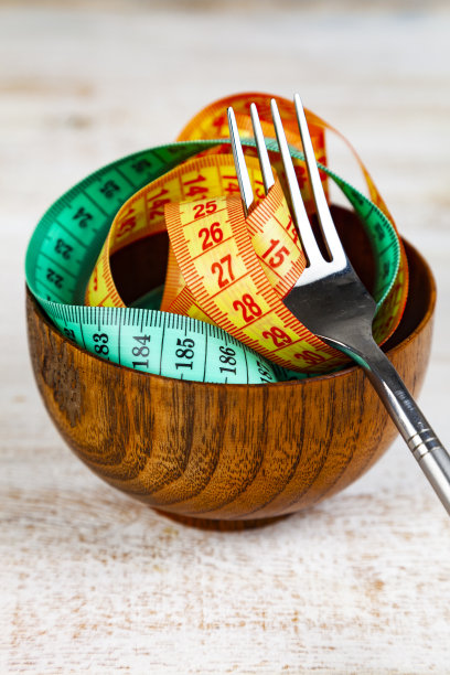 木碗和木叉里的卷尺。图片下载