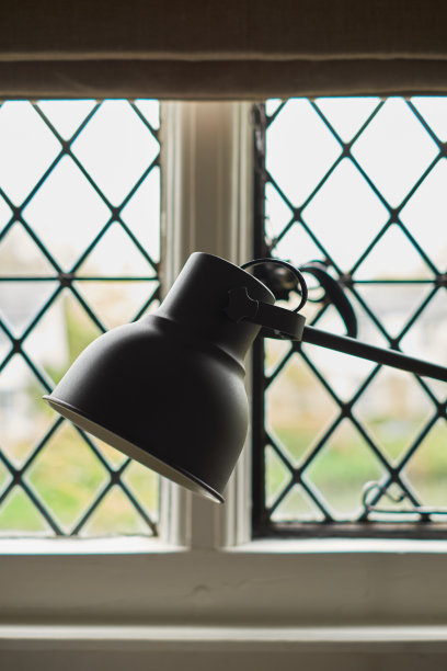 黑色台灯在室内对着菱形窗户。商业或教育概念与地方为您的文本。室内的碎片，极简主义背景。图片下载