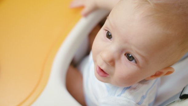 可爱的婴儿坐在家里的椅子上图片下载