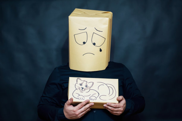 情感的概念。一个男人手里拿着一只小猫。脸上流露出极度失望的表情。一滴眼泪滴下。图片下载