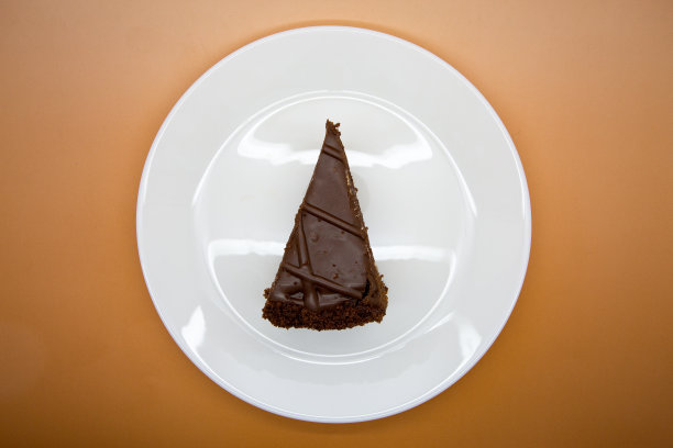 白色盘子上的三角形巧克力蛋糕图片下载