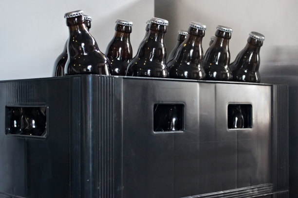 啤酒瓶子放在储藏室的一个旧塑料盒子里。图片下载