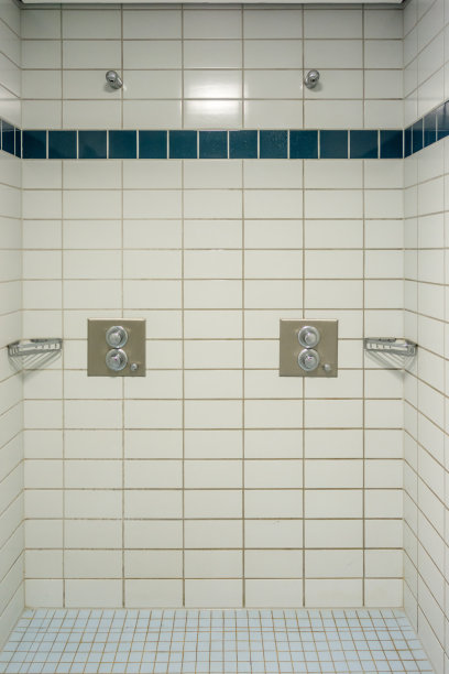 在体育馆里的一间全贴瓷砖的浴室里有几间淋浴房图片下载