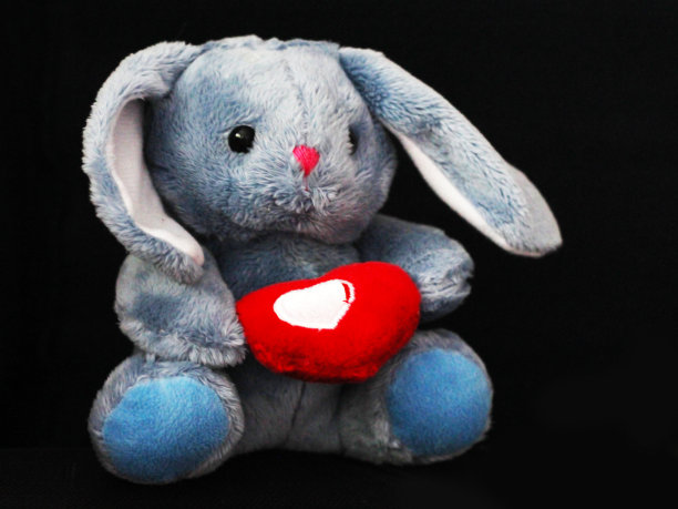 黑色背景上有爱心的兔子玩具图片下载
