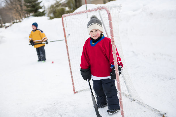 不错两个兄弟在街上打曲棍球，玩得很开心图片下载