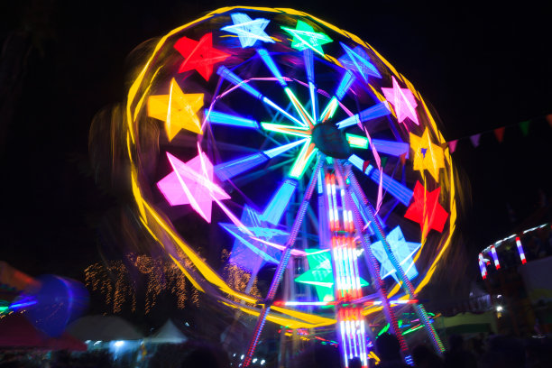 摩天轮是一种由带有多个载客部件的直立旋转轮组成的游乐设施。采购产品好玩的公园，游乐园，游乐场，活动，吸引和运动的概念。图片下载