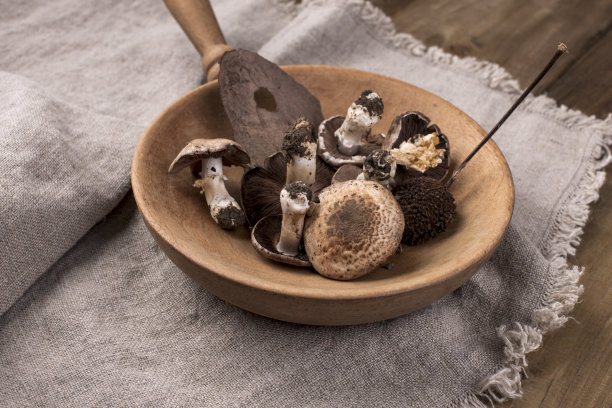 木色背景下平底锅里的蘑菇。复古照片和乡村风格的餐巾。自由空间的文本，俯视图。图片下载