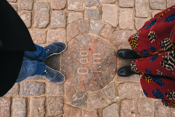 一对男人和女人脚一个男人和一个女孩标记零公里。旅游主题背景生活方式时尚理念图片下载