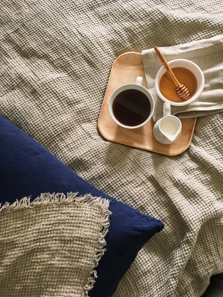 托盘上放着蜂蜜和一杯热茶在床上，慵懒的早晨，暖暖的冬日心情被罩上图片下载