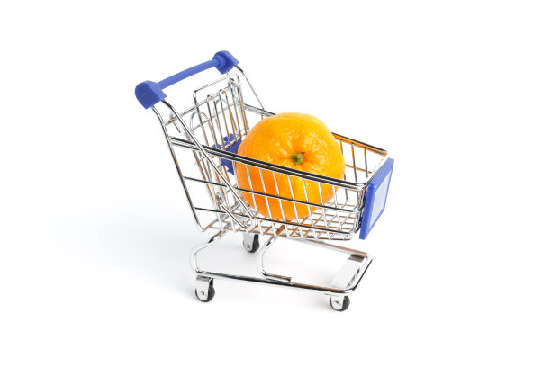 熟透多汁的橘子躺在超市的手推车上，背景是白色的。概念图图片下载