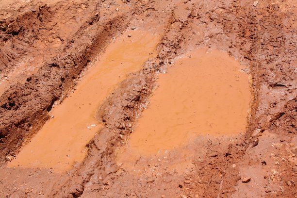 泥泞的红色水站在新制造的轮胎痕迹图片下载