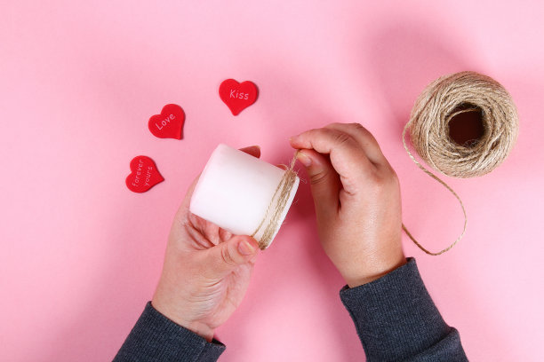 Diy。情人节蜡烛。用你自己的双手来装饰2月14日的节日，可以用蜡烛、麻绳和心形。前视图。工作坊上的照片，一步一步来。工艺品。图片下载