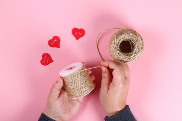 Diy。情人节蜡烛。用你自己的双手来装饰2月14日的节日，可以用蜡烛、麻绳和心形。前视图。工作坊上的照片，一步一步来。工艺品。图片下载