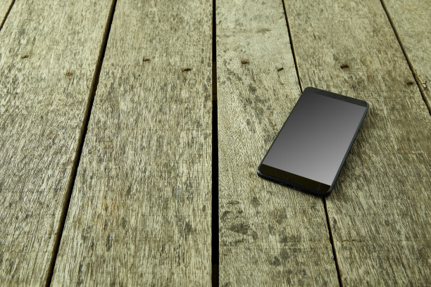 智能手机与交易在旧木桌上的股票交易和商业金融的概念图片下载