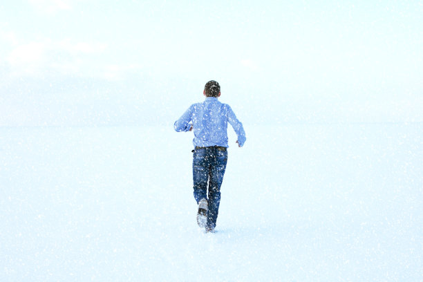 冬天，穿衬衫的人跑过冰冻的大海。冬天在海边穿着便服的孤独男子。年轻人在冬季的海景上休息。图片下载
