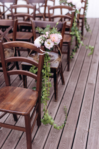 即将离任的婚礼。装饰工作室。绿色草坪上的棕色木椅。婚礼喜庆的拱门。为客人准备的白色扶手椅图片下载