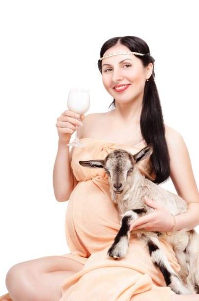 一个美丽的年轻孕妇和一只山羊的肖像图片下载