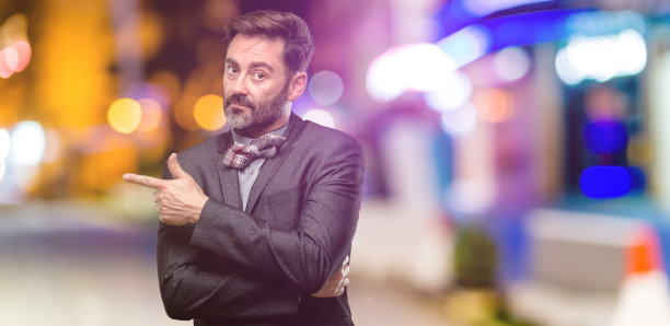 中年男子，留着胡子，打着领结，手指向一边图片下载