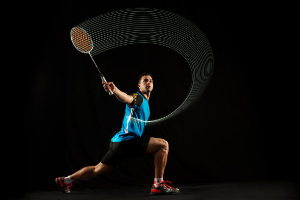 年轻男子羽毛球运动员的黑色背景图片下载