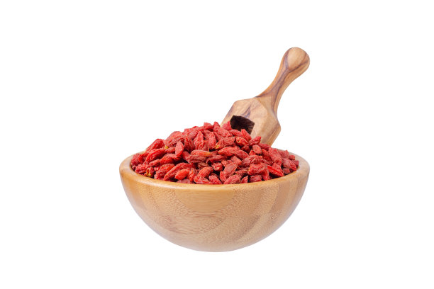 枸杞在一个木碗和一勺孤立的白色图片下载