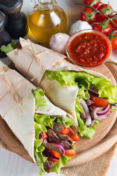 照片上的墨西哥三明治食物，玉米煎饼，菲希塔，玉米饼，玉米粉圆饼，牛肉，鸡肉，新鲜蔬菜在乡村的木制背景。快餐的概念。健康的午餐小吃。副本的空间。图片下载