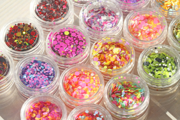 多色亮片设计的钉子在一个罐子。在jar闪闪发光。指甲用锡箔。组照片。闪闪美丽，闪闪发光。明亮的背景闪光。俯视图图片下载