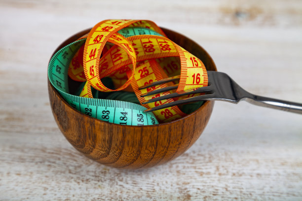 木碗和木叉里的卷尺。图片下载