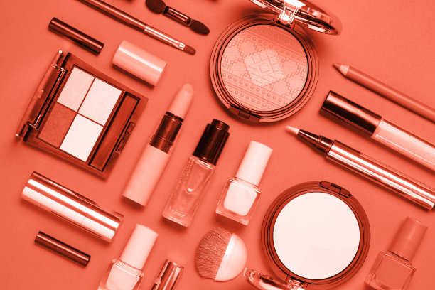 珊瑚色装饰化妆品在粉红色的背景。图片下载