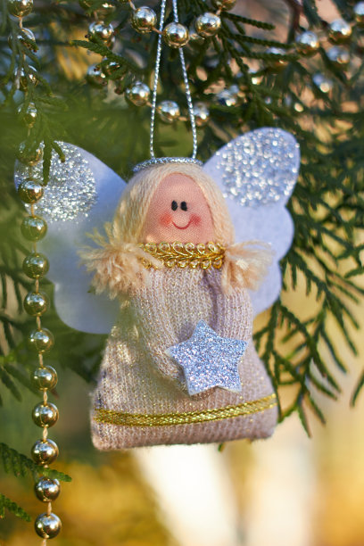 节日装饰。树枝上的圣诞天使。金珠子。手工圣诞树玩具。自然的户外照片。寒假。新年快乐，圣诞快乐。图片下载