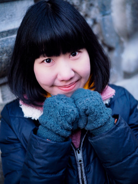一个在冬天看着镜头微笑的中国女人。图片下载