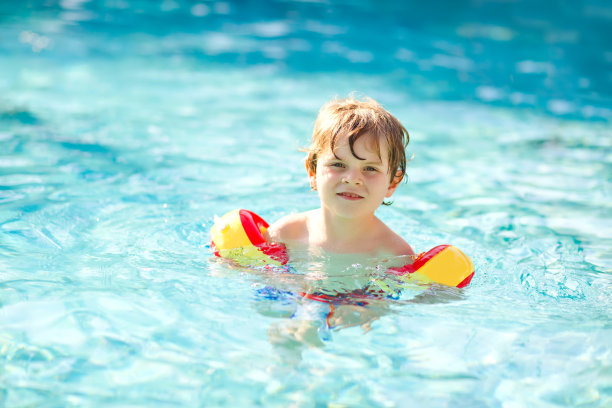 快乐的小男孩在游泳池里玩。积极快乐健康的学前儿童学习游泳。有安全的漂浮或游泳。家庭，假期，夏天的概念图片下载