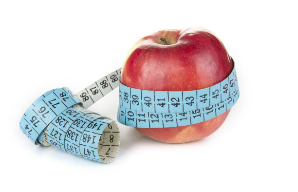 用卷尺绕着苹果。饮食和减肥的概念图片下载