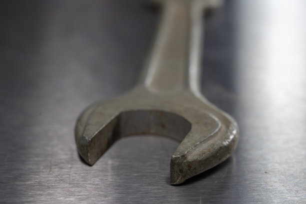 在车间的金属桌子上的扳手和螺母。用于小型机械维修的机修工配件。光背景。图片下载