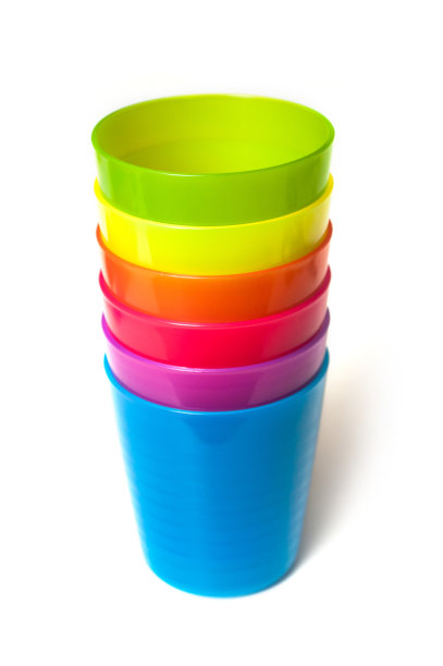 白色背景上的彩色婴儿塑料杯图片下载
