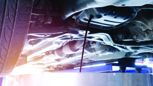 当机油更换时，机油正从汽车下面的发动机流出。维护和延长汽车的使用寿命。图片下载