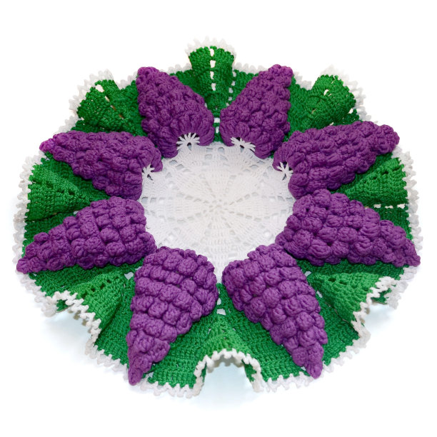 孤立的钩编小桌布形状的紫罗兰葡萄与绿色的叶子。前视图。图片下载