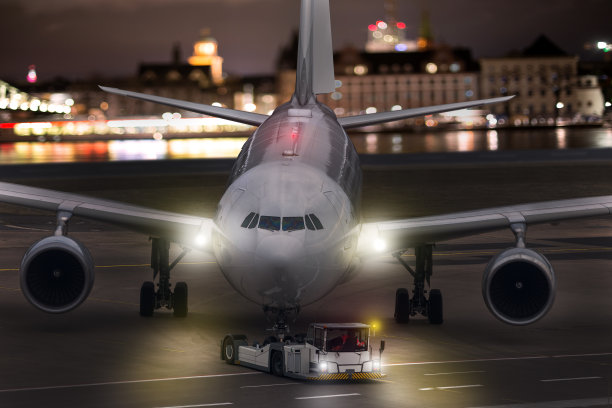 一架飞机在夜间被拖在机场图片下载