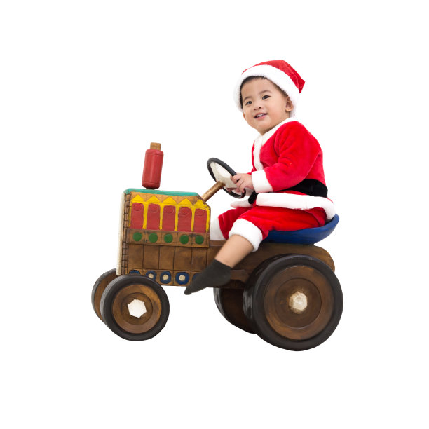 快乐的亚洲婴儿男孩笑，在圣诞老人的服装和坐在玩具复古木制拖拉机孤立在白色背景的乐趣图片下载