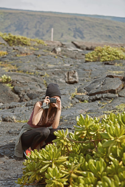 一个女孩旅行者在火山熔岩上拍照图片下载