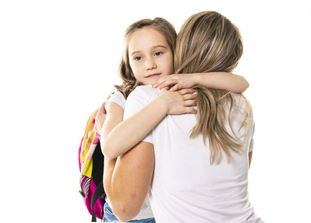开学的第一天，一位母亲拥抱着她的小女儿说再见图片下载