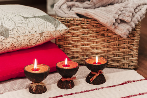 燃烧的spa香薰蜡烛椰子壳在背景枕头和包裹图片下载