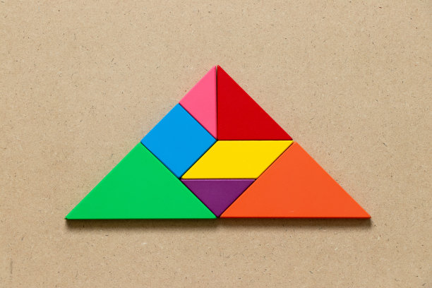 颜色七巧板拼图在三角形形状的木材背景图片下载